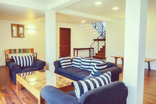 Sofas with striped cushions around a coffee table in the lobby at Kandy Casa