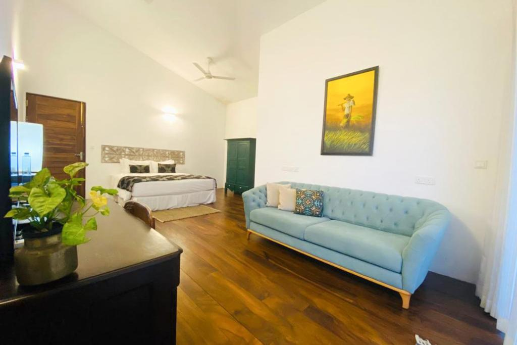 A Superior Double Room with its sofa, bed and a painting on the wall