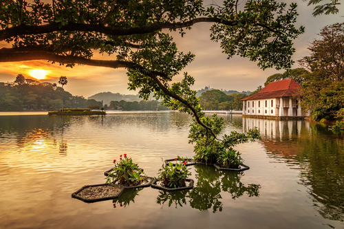 Kandy Lake at sunset, with a white colonial building on the water’s edge