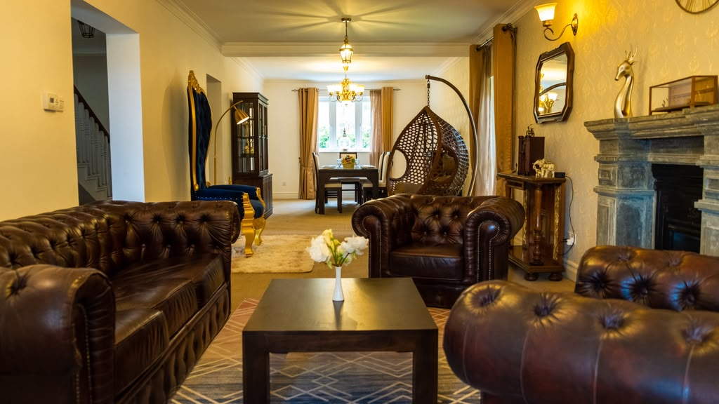Leather Chesterfield sofas and a fireplace in the living room at Little England