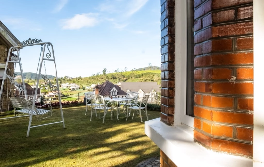 A garden swing and chairs on the lawn at Little England