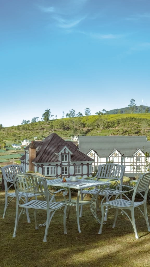 Garden furniture on the terrace at Little England, with the hills behind