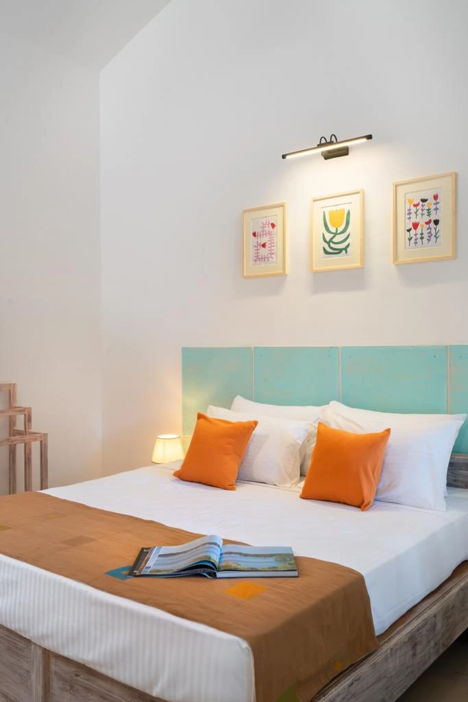 Orange cushions on the king bed in a Deluxe Double Room