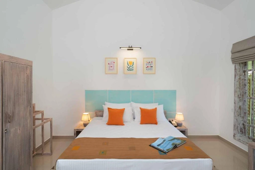 The king bed in a Deluxe Double Room under framed prints
