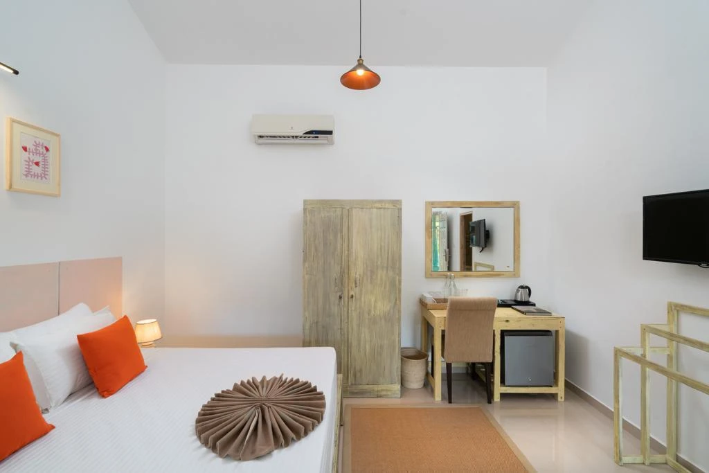 The desk, wardrobe, television and mini fridge in a Deluxe Double Room