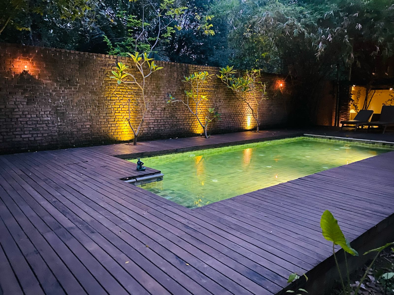 The lit pool and timber deck at Varanya in the evening