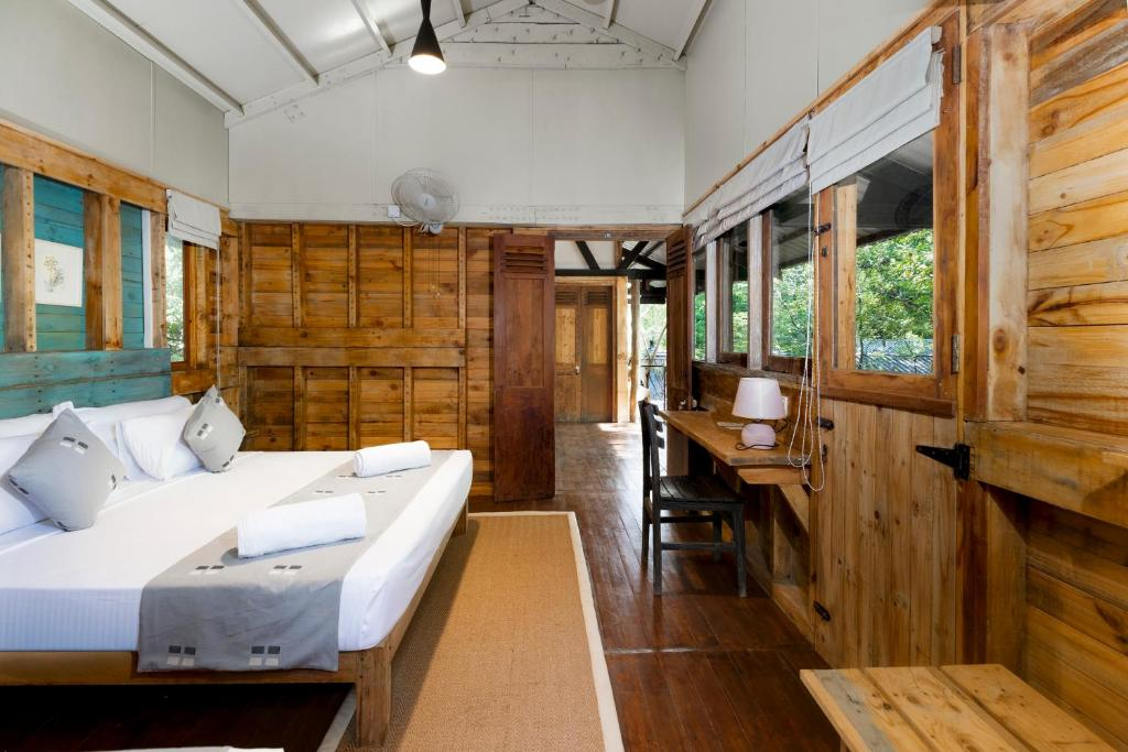 A timber-panelled guest room at Varanya with a double bed and writing desk