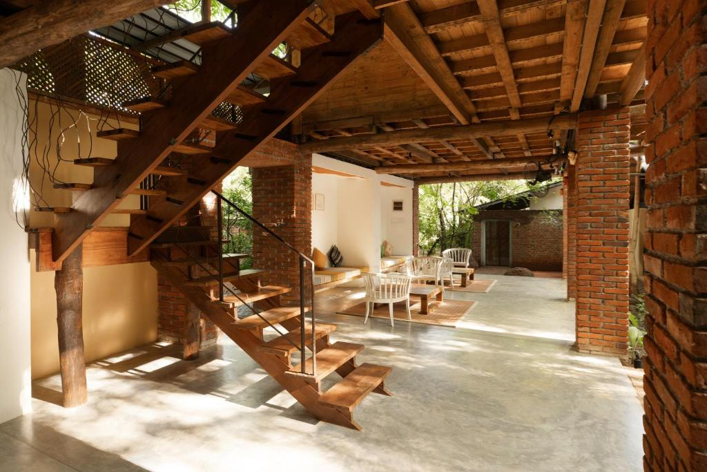 The open lobby at Varanya with its timber staircase and brick pillars