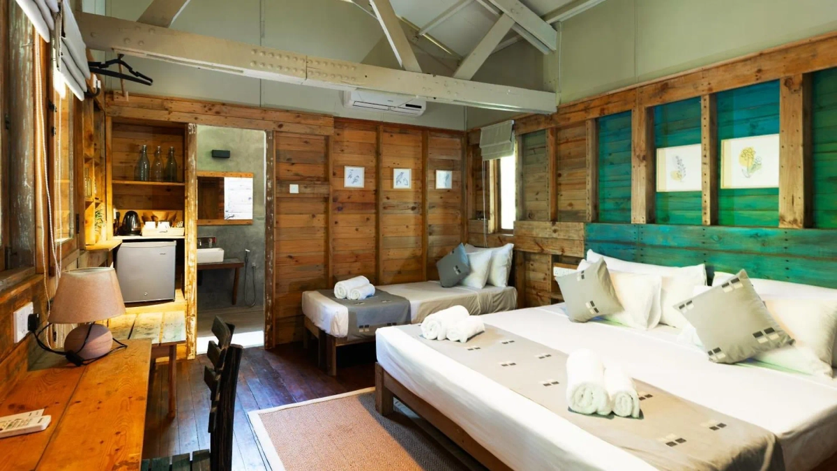 The queen bed and single bed in a Triple Room with Pool View